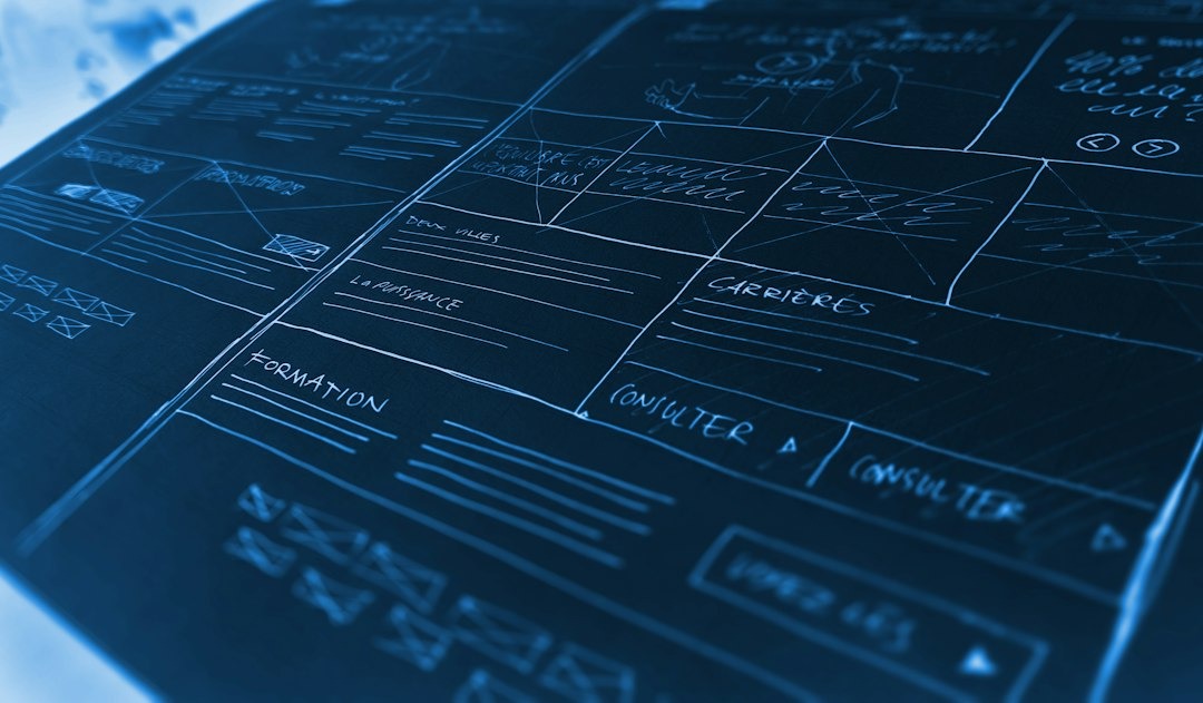 Website wireframe design hand-drawn with white lines on a dark surface.